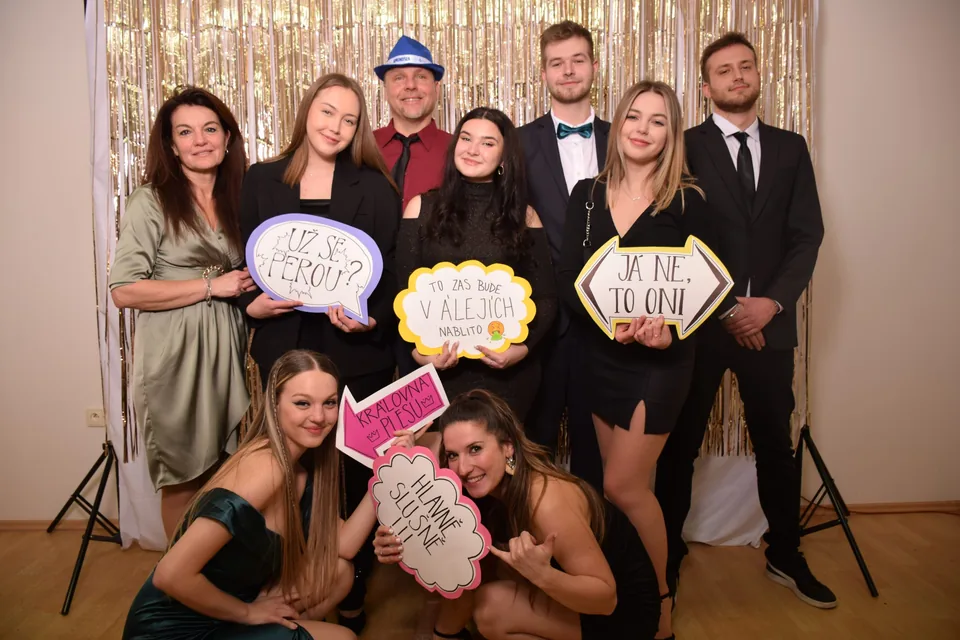 Velká skupina přátel s rekvizitami ve fotokoutku